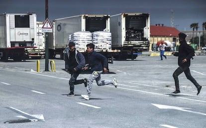 Jóvenes marroquíes corren ante la presencia de la Guardia Civil en el puerto de Ceuta. 