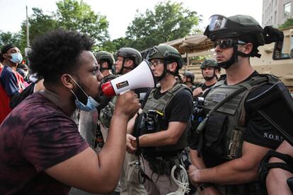 Un manifestante alza la voz megáfono en ristre ante las fuerzas del orden en Washington DC el pasado miércoles.