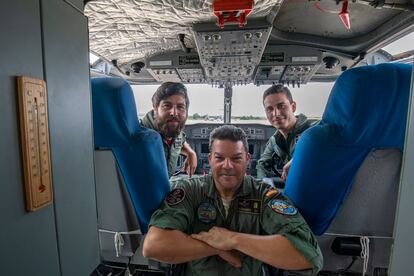 Los pilotos Aitor Bellido, izquierda, y David Juan, derecha, posan junto al mecánico Juan Sánchez en su hidroavión, en la base militar de Torrejón de Ardoz en Madrid.