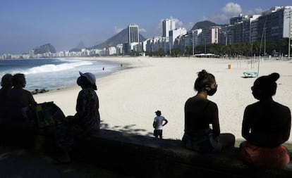 Un grupo de personas se sitúan en las rocas en la playa de Leme, este sábado. Río de Janeiro es una de las ciudades brasileñas más afectadas por la pandemia, con casi 20.000 muertos —la supera por poco São Paulo, que tiene el doble de población— y cerca de 220.000 infectados de coronavirus.