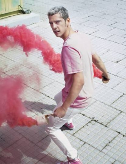 Eduardo Casanova posa para ICON mientras tiñe la capa de ozono de rosa. Lleva camiseta y pantalón de Levi's y zapatillas Converse.