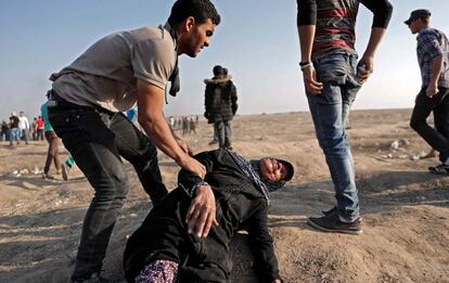 Un joven ayuda a una anciana desvanecida debido al gas lacrimógeno, durante las protestas en la Franja de Gaza. 