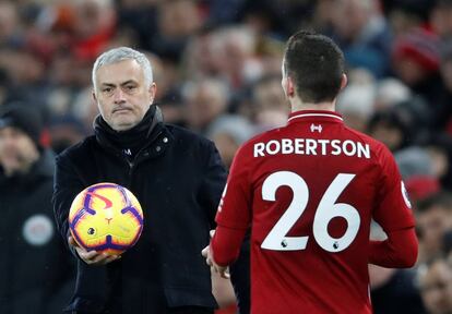 El entrenador del Manchester United, José Mourinho entrega el balón al jugador del Liverpool, Andrew Robertson, durante su último partido como entrenador de los "Diablos Rojos", el 16 de diciembre de 2018.