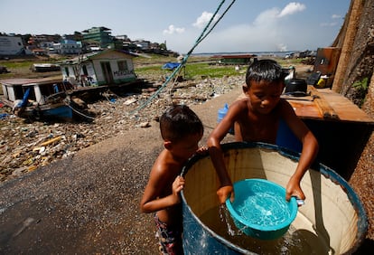 Niños se bañan antes de ir a la escuela, en Manaos (Estado de Amazonas). Más de 110.000 personas han sido afectadas por la sequía, según las autoridades, ya que los peces muertos afectan el acceso a comida y contaminan la principal fuente de agua.