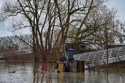 Un residente mueve un contenedor de basura durante la crecida del río Sena cerca de Conflans Sainte Honorine, a las afueras de París, el 25 de junio de 2018.