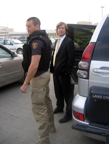 El juez Pedraz, escoltado por un policía nacional, en el aeropuerto de Bagdad.