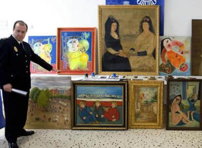 Un policía nacional muestra las trece pinturas de autores como Goya y Pinazo, algunas de ellas falsas