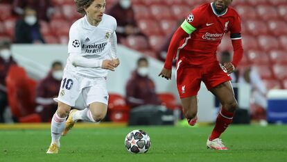 Modric conduz a bola contra pressão de Wijnaldum durante a partida de quartas de final da Champions entre Liverpool e Real Madrid.