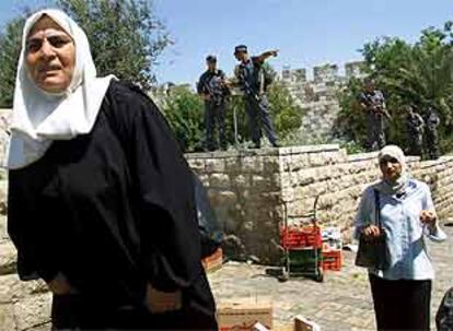 Dos mujeres pasan por el lugar en el que se registró un tiroteo contra policías israelíes, en Jerusalén.