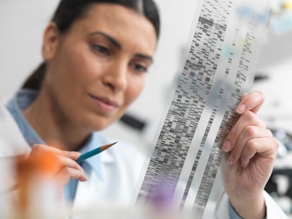 Una científica examina un panel de secuenciación genómica en un laboratorio de investigación genética