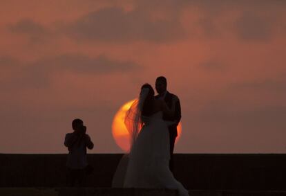 Una pareja egipcia posa para un fotógrafo de bodas durante la puesta del sol en Alejandría, Egipto.