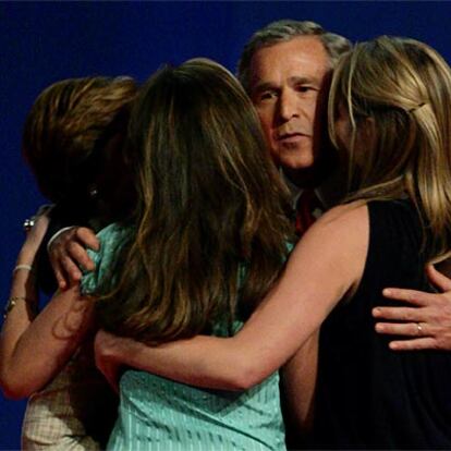 Bush abraza a su esposa e hijas tras el último debate en Arizona.