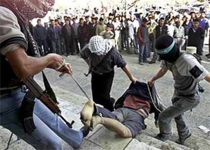 Palestinos armados de Al Fatah arrastran el cuerpo sin vida de uno de los acusados de colaboracionismo.