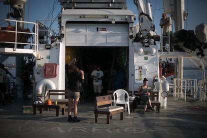 Una activista lee sentada en la popa del barco mientras el capitan (arriba) conversa con la primera oficial (centro).