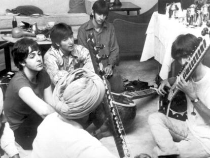 Paul McCartney, John Lennon y Ringo Starr observan a George Harrison mientras toca el sitar durante una visita a India en 1966.
