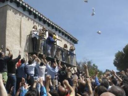 El alcalde de Palencia, Alfonso Polanco (camiseta amarilla) lanza bolsas de pan y quesillo a los miles de participantes en la Romería de Santo Toribio.