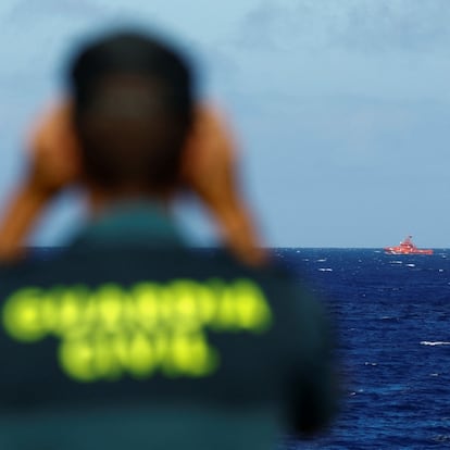 A Civil Guard officer watches a rescue boat searching for possible survivors after the sinking of a wooden boat with migrants near the port of La Restinga, on the island of El Hierro, Spain, September 28, 2024. REUTERS/Borja Suarez