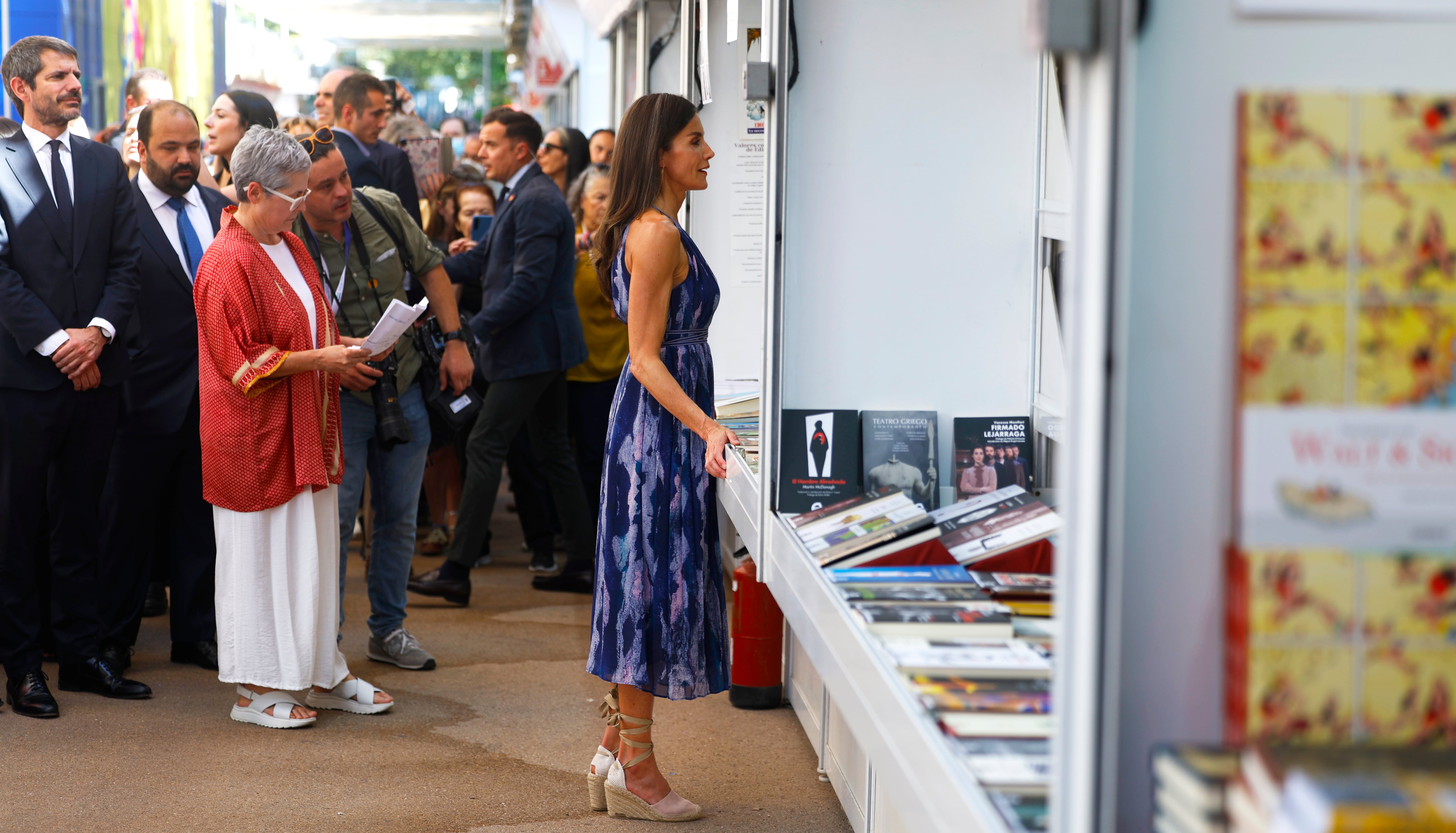 La reina Letizia ante una de las casetas de la Feria del Libro de Madrid, durante la inauguración este viernes en el parque del Retiro.
