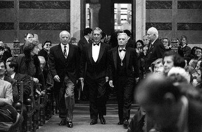 En el centro de la imagen, Mario Vargas Llosa en 1996 en su entrada a el salón de sesiones de la Real Academia, flanqueado por Emilio Lledó a su izquierda y Luis Goytisolo a su derecha.