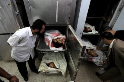 Varios palestinos observan los cadáveres de los cuatro milicianos muertos ayer en un ataque israelí en la costa de Gaza.