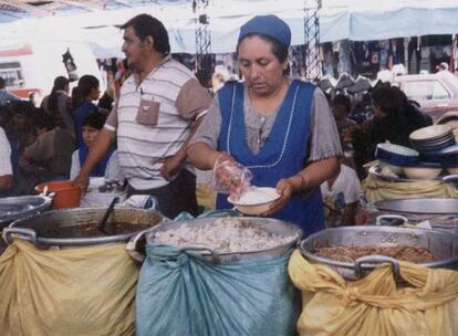Una boliviana en su puesto, abierto con microcrédito.