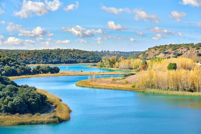 CIUDAD REAL Y ALBACETE. LAGUNAS DE RUIDERA. En puridad del término, las 15 cubetas de agua que forma el río Guadiana a su paso por esta zona de Castilla-La Mancha no son lagos, sino remansos del cauce, separados por tobas calizas y otros fenómenos kársticos. Solo dos de las lagunas de Ruidera, la Blanca y la Taza, son verdaderas lagunas. Pero más allá de los tecnicismos, el común de los mortales disfruta de este humedal que rompe la imagen tópica de secano y cereal de las provincias de Ciudad Real y Albacete. Son en total 30 kilómetros de conjunto lagunar donde oficialmente nace el río Guadiana. Las 15 lagunas que lo forman se inundan unas a otras, formando singulares saltos y cascadas debido a las barreras travertínicas. El parque tiene una superficie de 3.772 hectáreas en total, y alberga una importante colonia de anátidas, porrones comunes, porrones moñudos, patos colorados, fochas, patos cuchara, cormoranes, garzas reales, aguiluchos laguneros, aguiluchos ratoneros y águilas perdigueras, entre 
otras aves que se pueden avistar.
