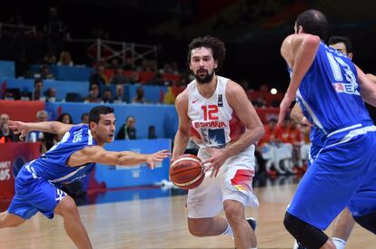 Sergio Llull (c) dribla a varios adversarios griegos antes de encestar.