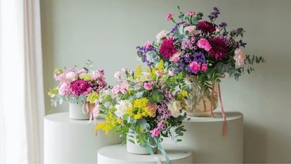 Tres ramos de flores en diferentes mesas circulares.