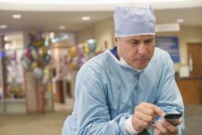 Médico usando un teléfono móvil.