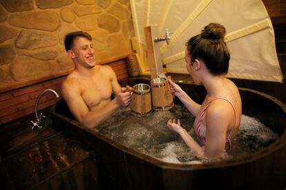 Una pareja toma un baño en el agua que contiene los ingredientes básicos de la cerveza (malta, lúpulo y levadura) mientras toman una cerveza Alhambra en un spa de Granada.