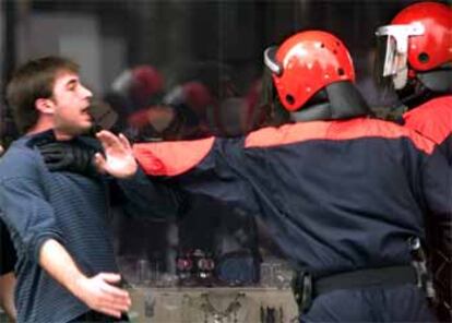 Un <i>ertzaina</i> forcejea con un simpatizante de la ilegalizada Batasuna en las inmediaciones del Ayuntamiento de San Sebastián.