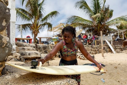 Khadjou encera su tabla en la playa de Yoff, en Dakar, Senegal. "Siempre veía hombres surfeando y me decía a mí misma: pero ¿dónde están las chicas?", cuenta Sambe. "Pensé: ¿por qué no voy a hacerlo yo, represento a mi país, represento a África y represento a Senegal como una niña negra?".