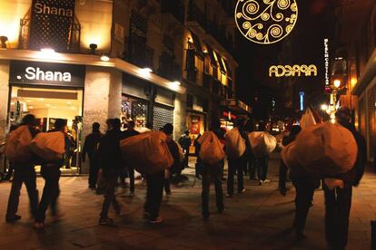 Manteros traslad&aacute;ndose por una calle de Madrid.