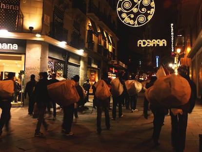 Manteros traslad&aacute;ndose por una calle de Madrid.