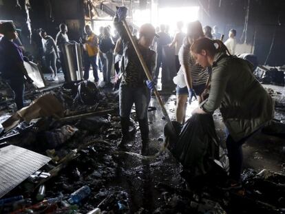 Voluntaris netegen dimarts una botiga destrossada ahir a la nit a Baltimore.
