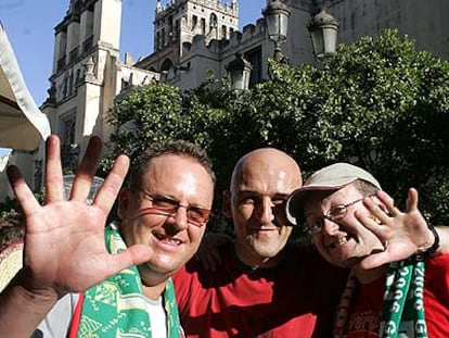 Tres aficionados del Liverpool, ayer, en las inmediaciones de la catedral de Sevilla.