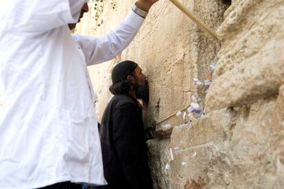 Un trabajador saca notas de las grietas en el Muro de los Lamentaciones, en Jerusalén.