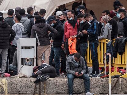 Varios inmigrantes se agolpan en el puerto de Arguineguín, en Gran Canaria, después de que Salvamento Marítimo rescatara durante la madrugada del pasado sábado a 294 inmigrantes de once pateras.