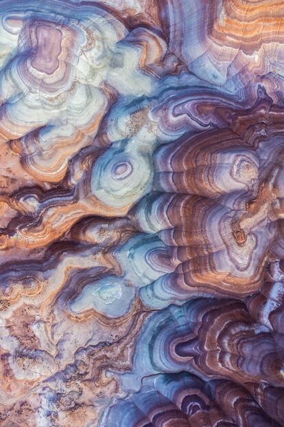 Las coloridas Bentonite Hills. Conocidas como las montañas arcoíris de Utah (EE UU), estas pintorescas formaciones del periodo Jurásico de color óxido están situadas cerca del parque nacional Capitol Reef. No es posible explorar la belleza del terreno a pie por la delicadeza de la superficie, que puede tardar años en sanar, pero sí existen carreteras para acercarse lo máximo posible sin dañar ni perjudicar el histórico paraje. En la imagen, vista aérea de Bentonite Hills, en Utah.