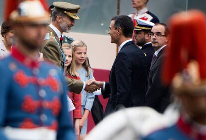 El rey Felipe VI estrecha la mano del presidente del Gobierno, Pedro Sánchez, en presencia de las infantas Leonor y Sofía, este viernes en Madrid.