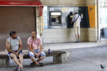 Un hombre retira dinero de un cajero automático del Banco de Chipre en Nicosia, Chipre, el 29 de julio de 2013.
