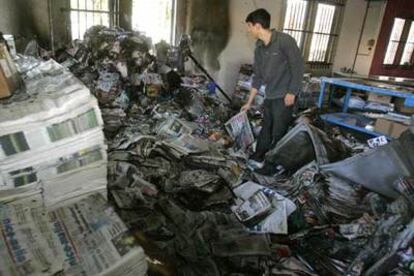 Un empleado del diario <i>Nice Matin,</i> de Niza, observa los restos del almacén incendiado.