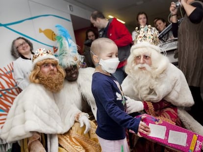 Un niño internado en el hospital de Sant Pau de Barcelona recibiendo ayer uno de los regalos recogidos en la campaña.