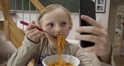 Ver dibujos en el móvil durante la comida, una práctica cada vez más habitual entre los niños.