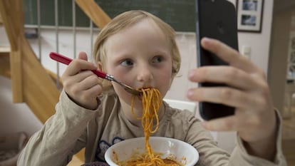 Ver dibujos en el móvil durante la comida, una práctica cada vez más habitual entre los niños.