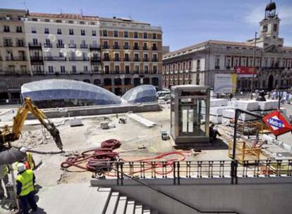 Obras de remodelación en Sol. Al fondo, los cristales de la entrada de la estación reflejan los rayos sobre la fachada de los edificios.