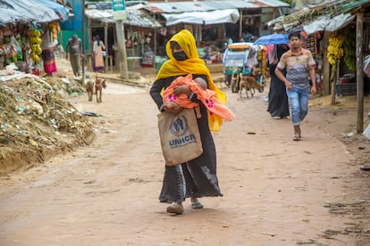 Una madre refugiada rohinyá camina con su bebé por una carretera en uno de los campamentos improvisados en Cox's Bazar, el 24 de agosto de 2022. Las mujeres sufren un doble daño, aseguran desde Médicos Sin Fronteras (MSF). “Las consecuencias de la violencia sexual y de género son un tema aparte. Solo hay tratamiento para lesiones e infecciones de transmisión sexual, pero no hay apoyo mental ni vacunación”, lamentan.