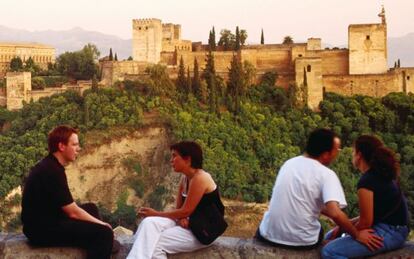 Turistas contemplando la Alhambra desde el mirador de San Nicolás, en el barrio del Albaicín (Granada).