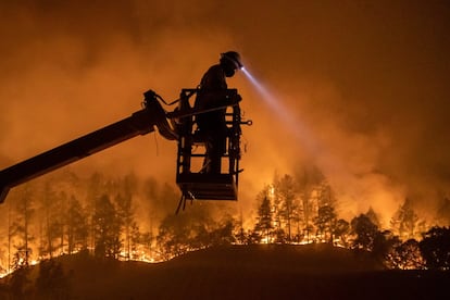 Un empleado de CableCom, instala un cable de fibra óptica durante los incendios forestales en Calistoga, en California (EE UU). Decenas de miles de personas tuvieron que dejar sus casas en los valle de Napa y Sonoma en California, debido a voraces incendios que han dejado tres muertos en esa zona del oeste de Estados Unidos famosa por sus viñedos.