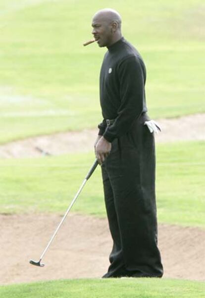 Michael Jordan, puro en ristre, juega al golf en Valencia.